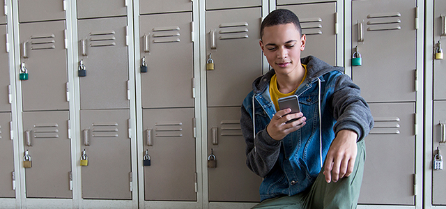 Boy on his mobile phone near lockers