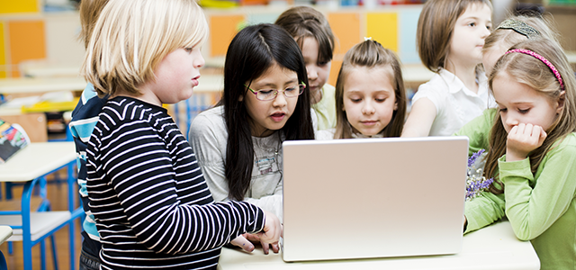 Group of kids collaborating at a computer